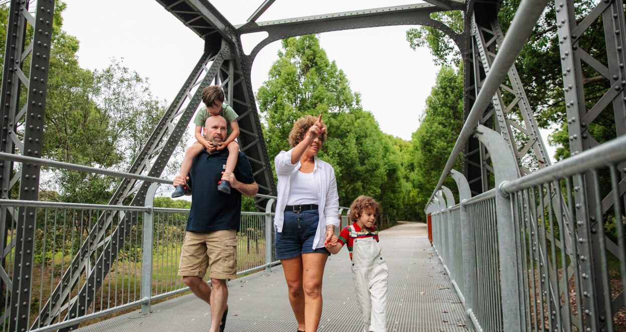 Family walking under Dunbible Bridge on the Northern River Rail Trail
