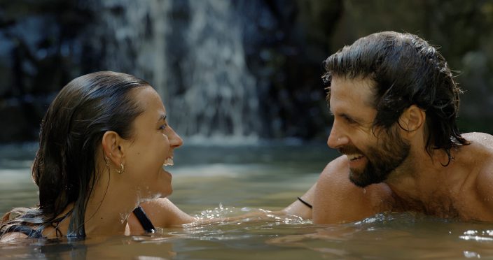 couple swimming at waterfall