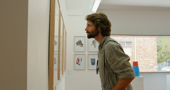 man looking at art in a gallery