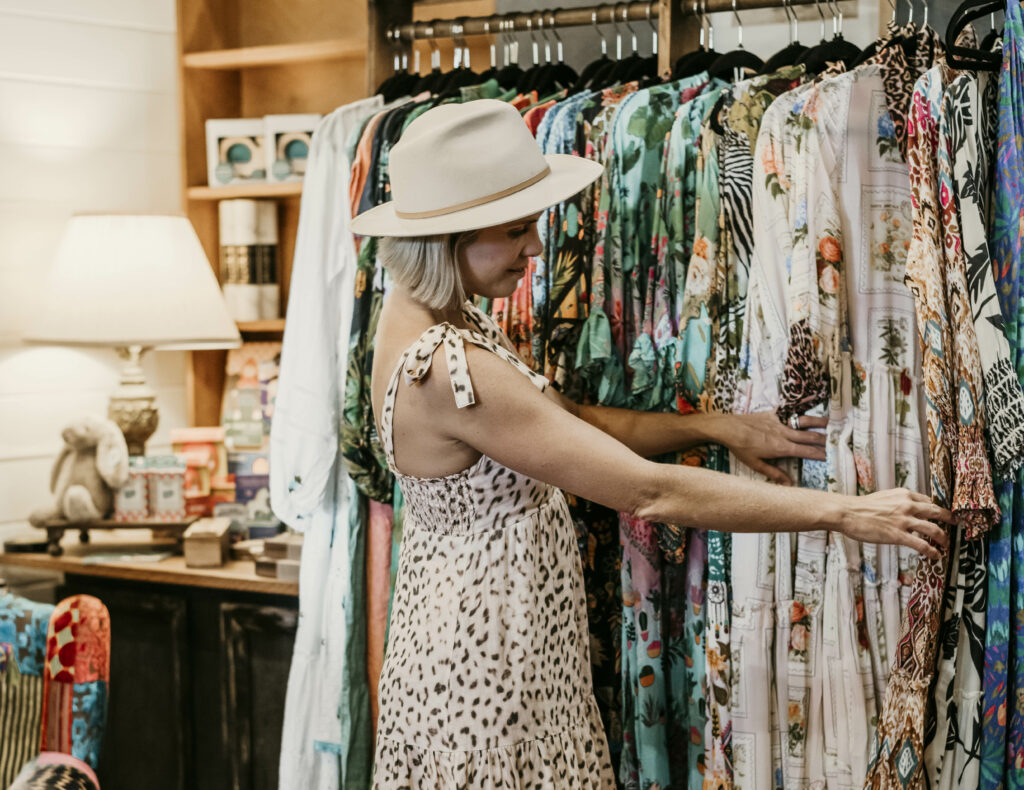 Woman looking thorugh rack of clothes in shop in Tyalgum