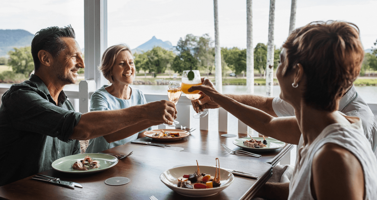Group of friends enjoying a meal at Tweed River House. Wollumbin Mount Warning in background.