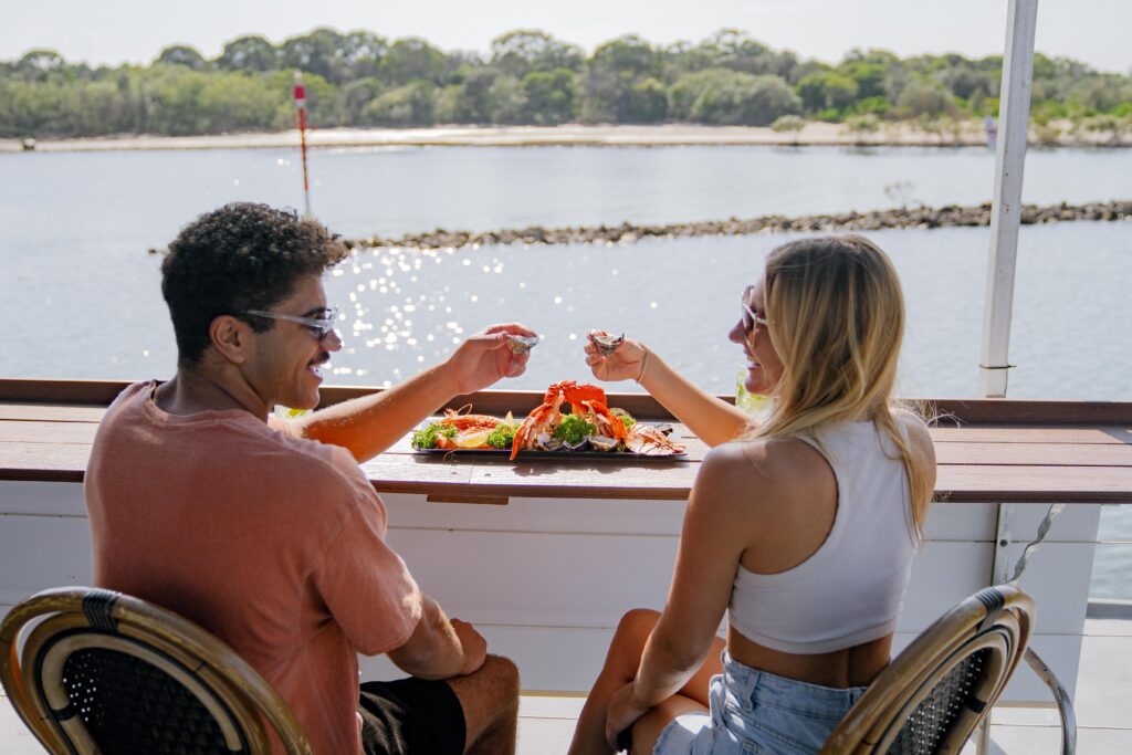 couple enjoying seafood platter on tweed eco cruises