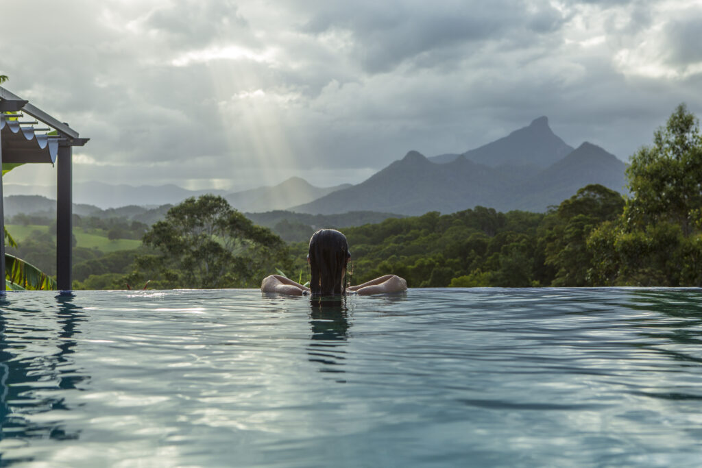 woman swims in pool with mountain views
