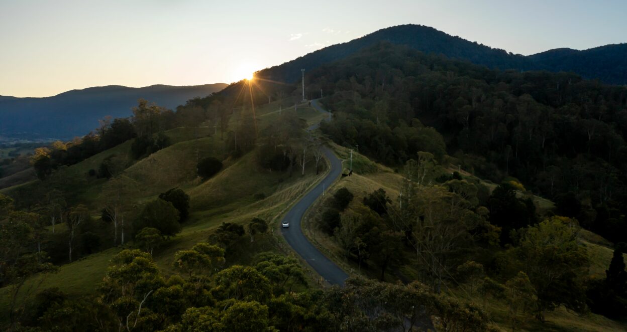 planning an ev holiday banner image of car in hinterland